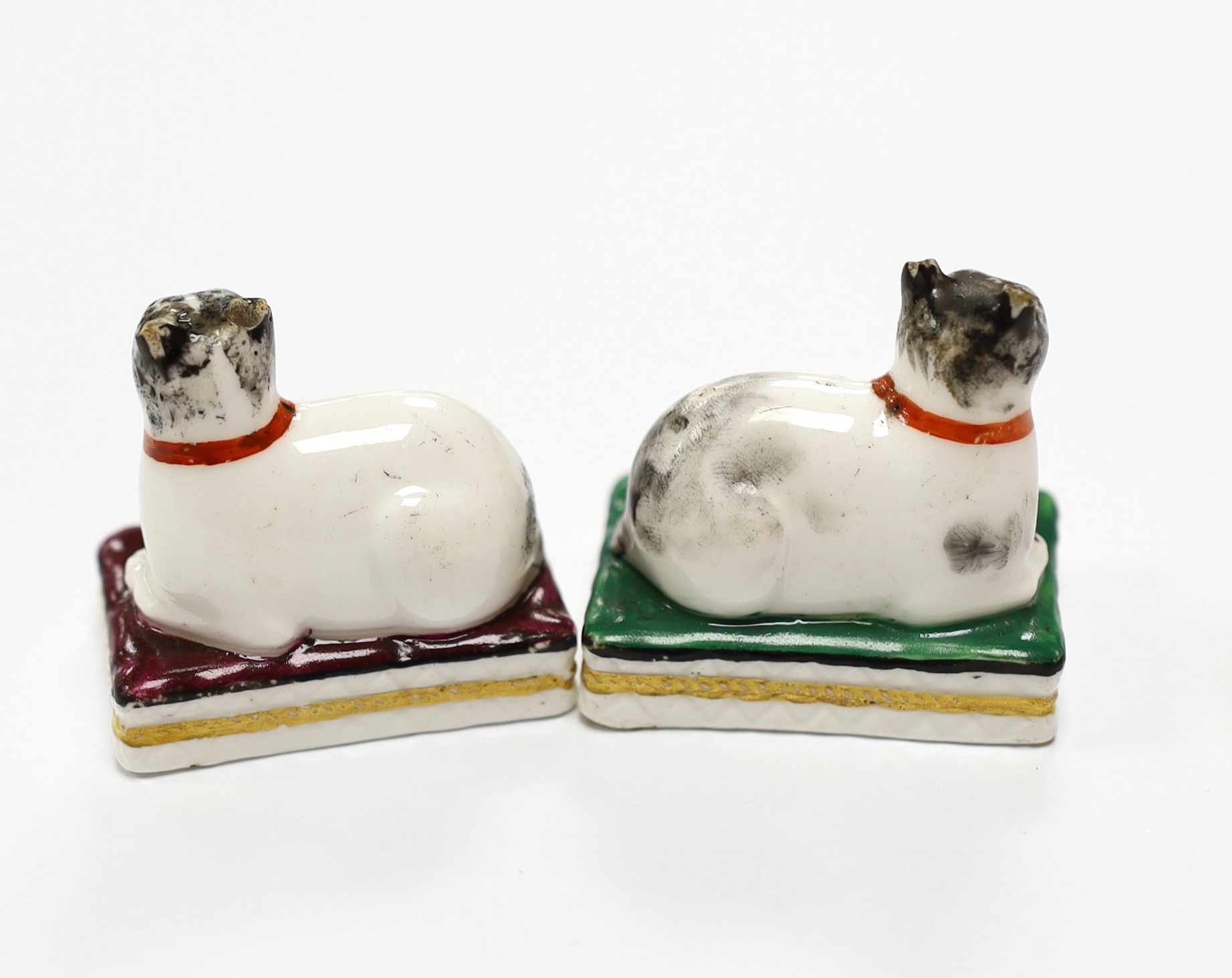 Two Derby porcelain models of recumbent cats on cushions, c.1825-35, 4.2 cm long